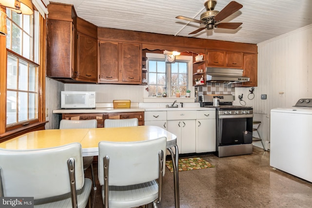 kitchen with white cabinetry, ceiling fan, stainless steel range oven, and washer / dryer