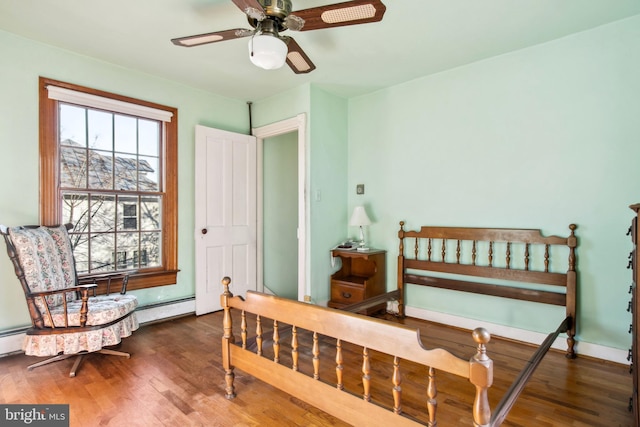 bedroom featuring baseboard heating, ceiling fan, and dark hardwood / wood-style flooring