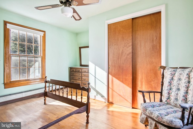 bedroom with ceiling fan, a closet, and wood-type flooring