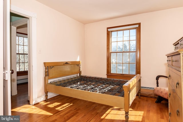 bedroom featuring a baseboard radiator and light hardwood / wood-style floors