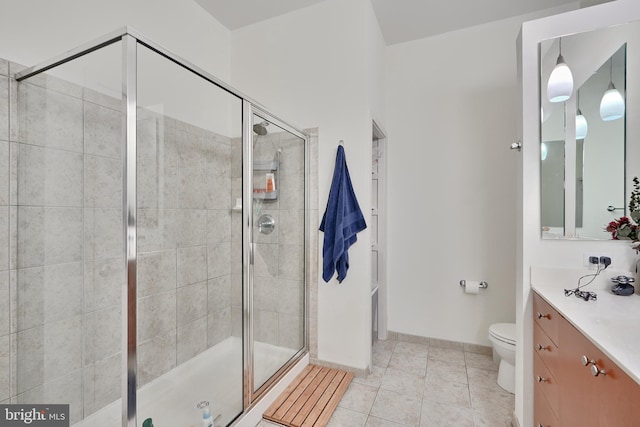 bathroom with tile patterned floors, vanity, an enclosed shower, and toilet