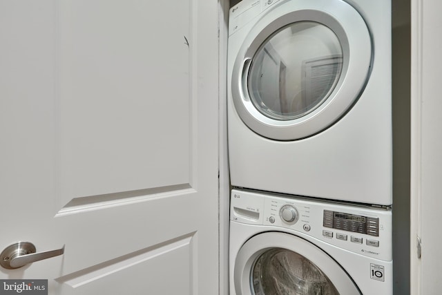 washroom with stacked washing maching and dryer