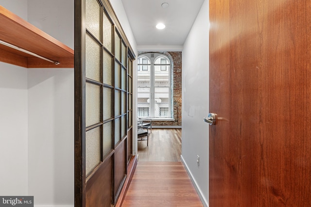 corridor with baseboards and wood finished floors