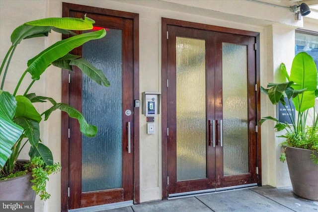 doorway to property with elevator and stucco siding