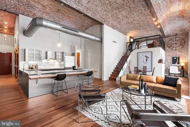 living area featuring brick ceiling, a high ceiling, and wood finished floors