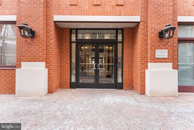 property entrance featuring brick siding and french doors