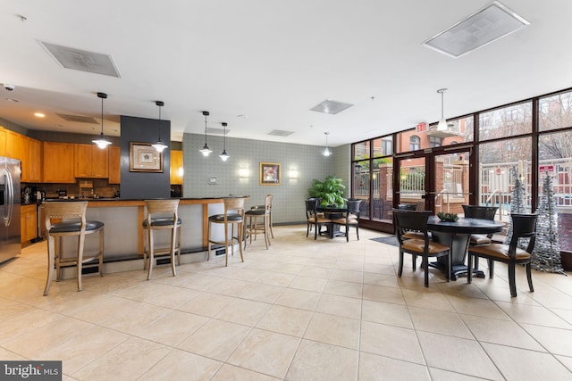 dining space featuring floor to ceiling windows, visible vents, and light tile patterned floors