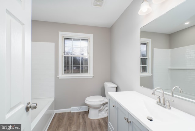 full bathroom with hardwood / wood-style floors, vanity, toilet, and washtub / shower combination