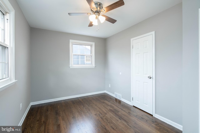 unfurnished room with ceiling fan and dark wood-type flooring