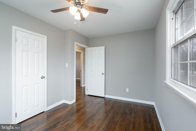 unfurnished bedroom featuring ceiling fan and dark hardwood / wood-style floors