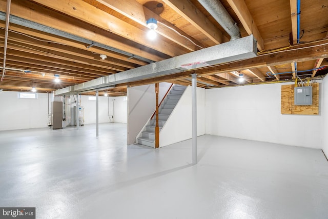 basement featuring electric panel and heating unit