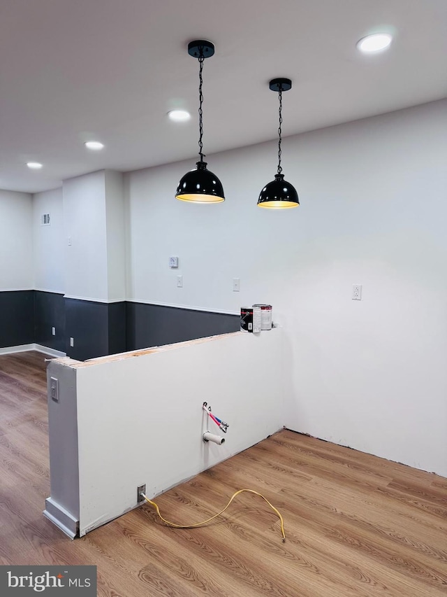 kitchen with hardwood / wood-style flooring and hanging light fixtures