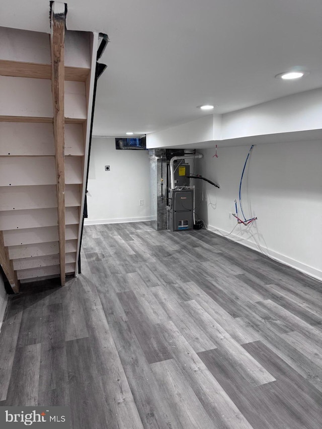 basement with wood-type flooring and heating unit