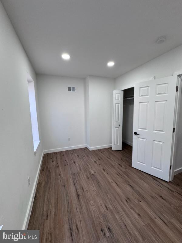 unfurnished bedroom featuring a closet and dark hardwood / wood-style floors