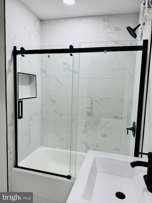 bathroom featuring sink and bath / shower combo with glass door