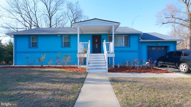 view of front of property featuring a garage and a front lawn