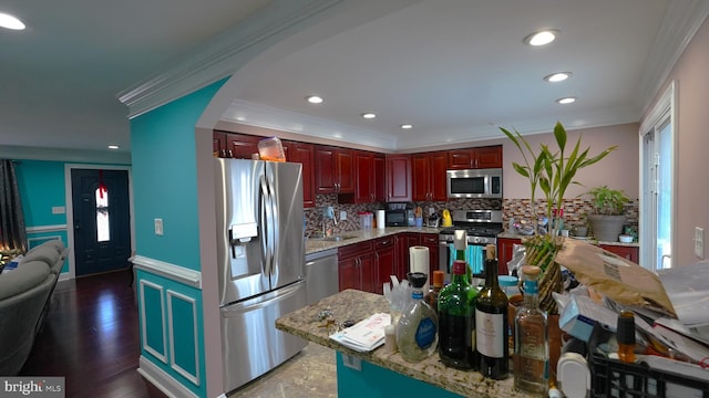 kitchen featuring decorative backsplash, dark hardwood / wood-style flooring, stainless steel appliances, and ornamental molding