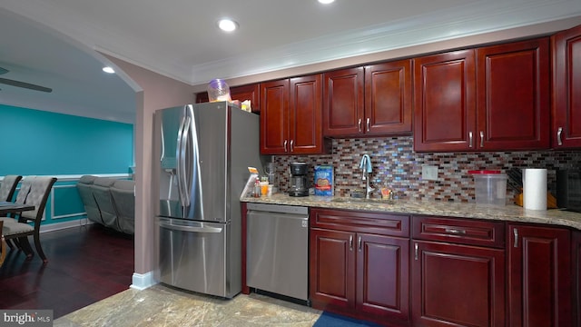 kitchen with light stone countertops, sink, backsplash, appliances with stainless steel finishes, and ornamental molding