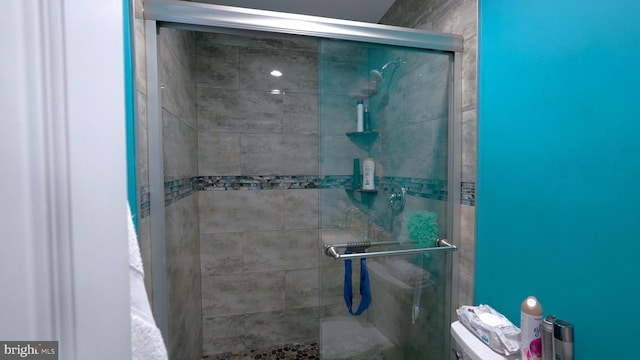 bathroom with an enclosed shower and toilet