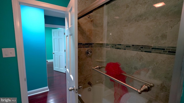 bathroom featuring wood-type flooring and tiled shower / bath