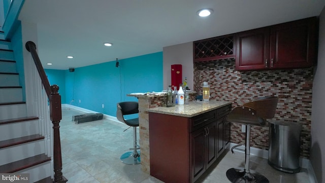 bar featuring backsplash and light stone counters