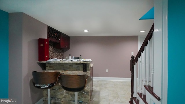 kitchen with backsplash, kitchen peninsula, and a kitchen bar