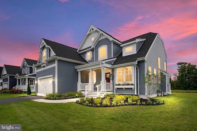 view of front of property with a lawn, a garage, and covered porch