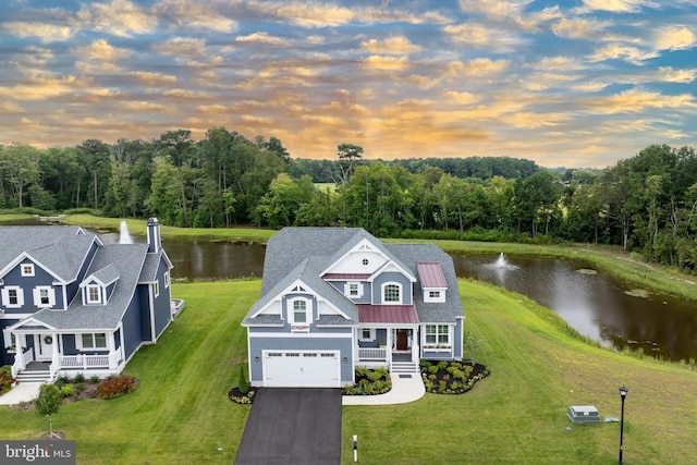 view of front of home featuring a water view, covered porch, and a garage