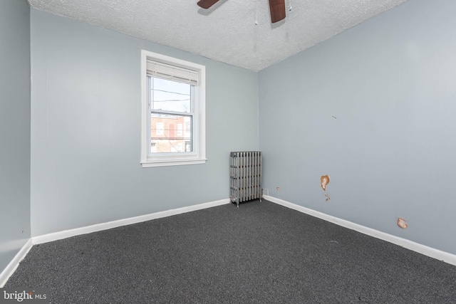 carpeted spare room with a textured ceiling, radiator, and ceiling fan