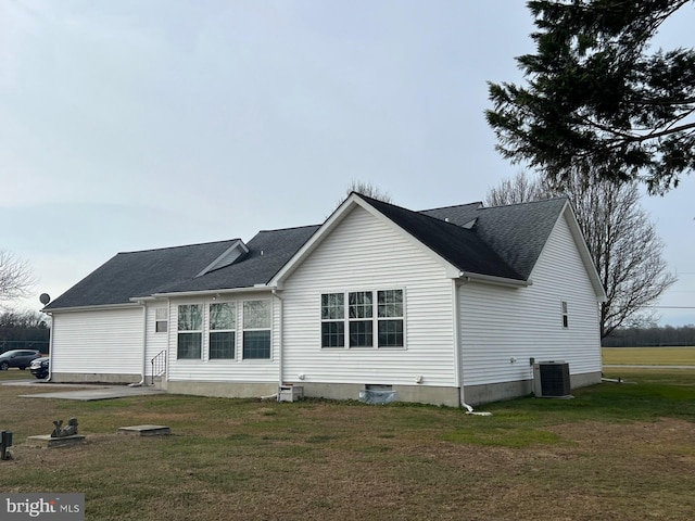 rear view of property featuring a yard and central AC unit