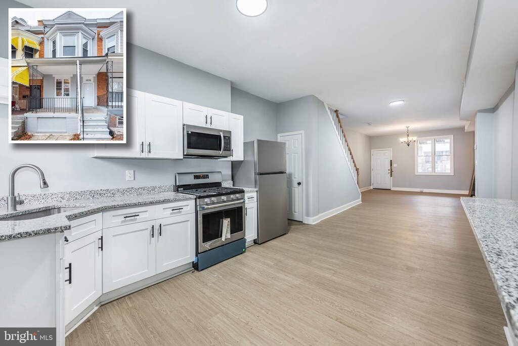 1636 N Ashburton St, Baltimore, MD 21216 - kitchen featuring a sink, appliances with stainless steel finishes, an inviting chandelier, and light wood-type flooring