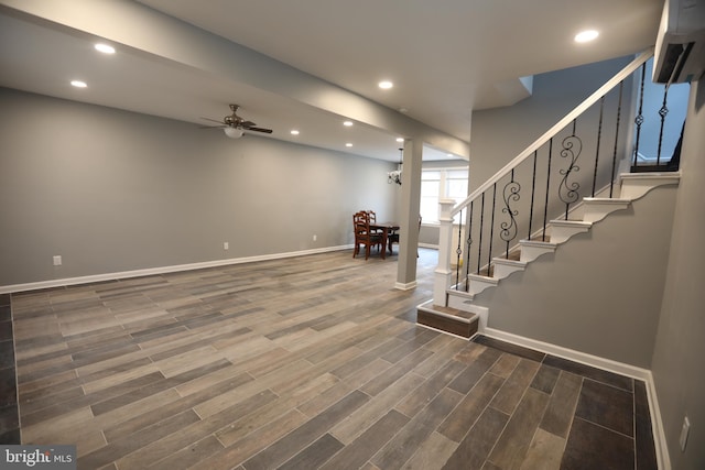 basement with ceiling fan and a wall unit AC