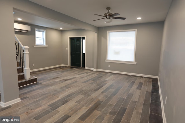 foyer with a wall mounted AC, ceiling fan, and dark wood-type flooring