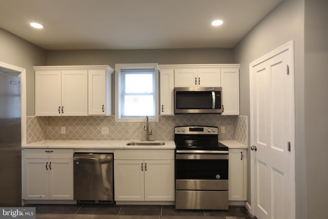 kitchen featuring backsplash, white cabinetry, sink, and stainless steel appliances