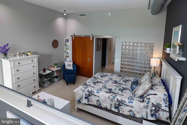 bedroom featuring a barn door and light colored carpet