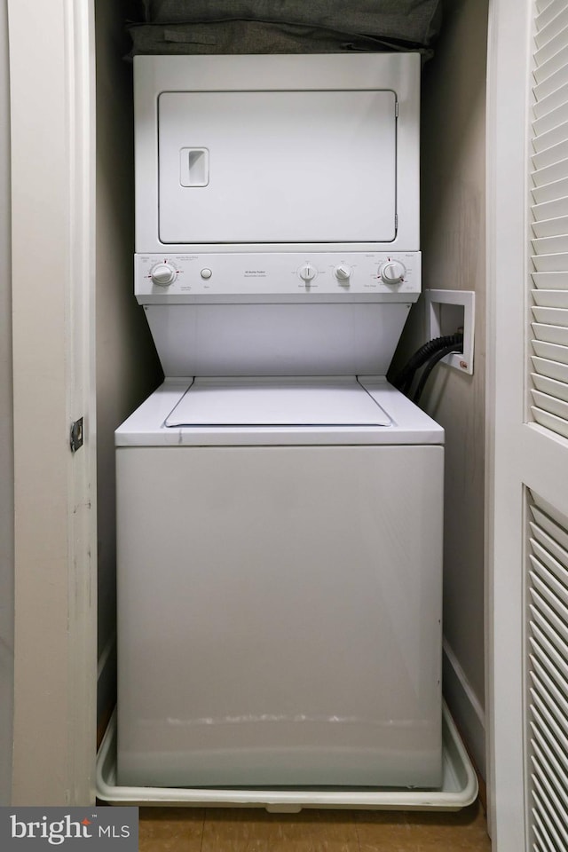 washroom with stacked washing maching and dryer