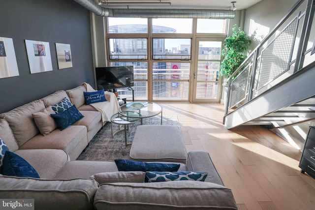 living room featuring wood-type flooring and a wall of windows