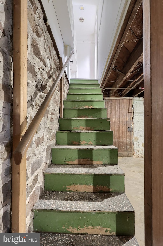 staircase featuring concrete floors