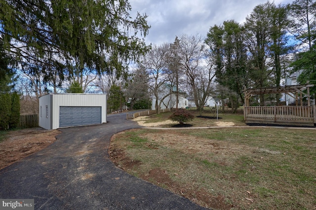 view of yard featuring a garage, an outdoor structure, and a wooden deck