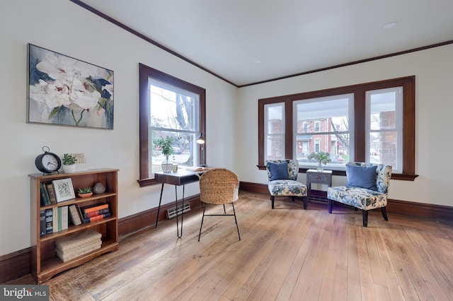 sitting room with light wood-type flooring and ornamental molding