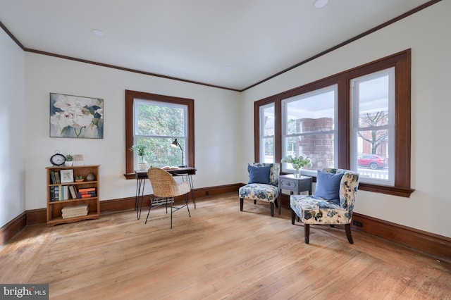 sitting room with light wood-type flooring and crown molding