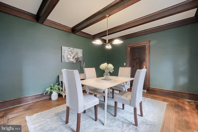 dining space featuring beam ceiling and wood-type flooring