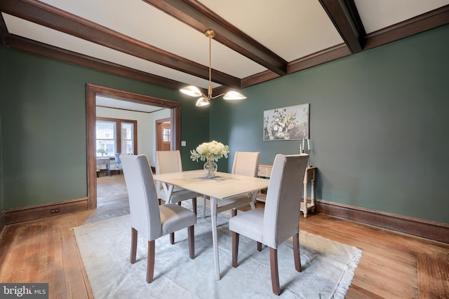 dining space featuring beamed ceiling and light wood-type flooring