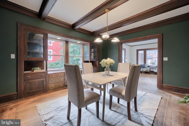 dining area with beam ceiling, light hardwood / wood-style flooring, and a notable chandelier