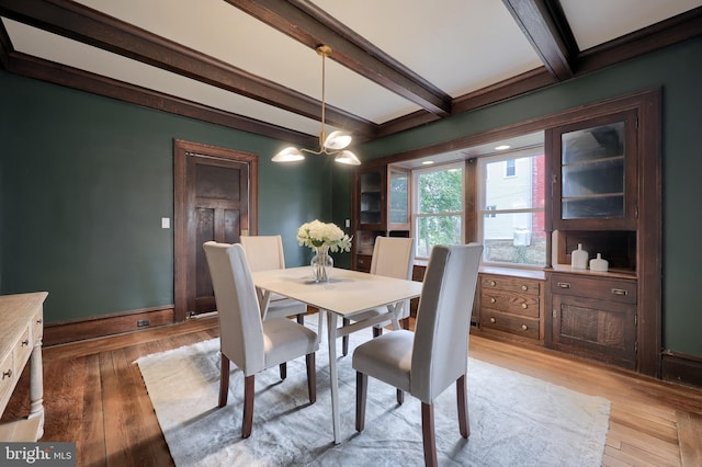 dining space with beam ceiling and light hardwood / wood-style flooring