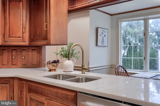 kitchen with light stone counters, sink, dishwasher, and ornamental molding