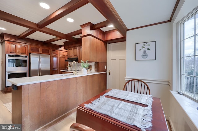 kitchen with coffered ceiling, sink, beam ceiling, kitchen peninsula, and stainless steel appliances