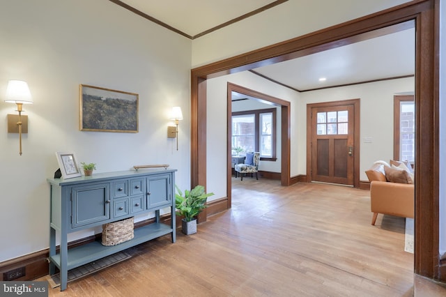 foyer entrance with light wood-type flooring and crown molding