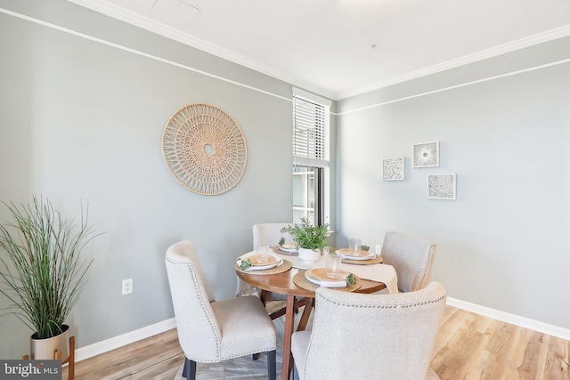 dining area with crown molding and light hardwood / wood-style flooring