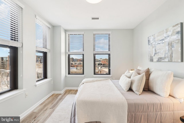 bedroom with light wood-type flooring and multiple windows